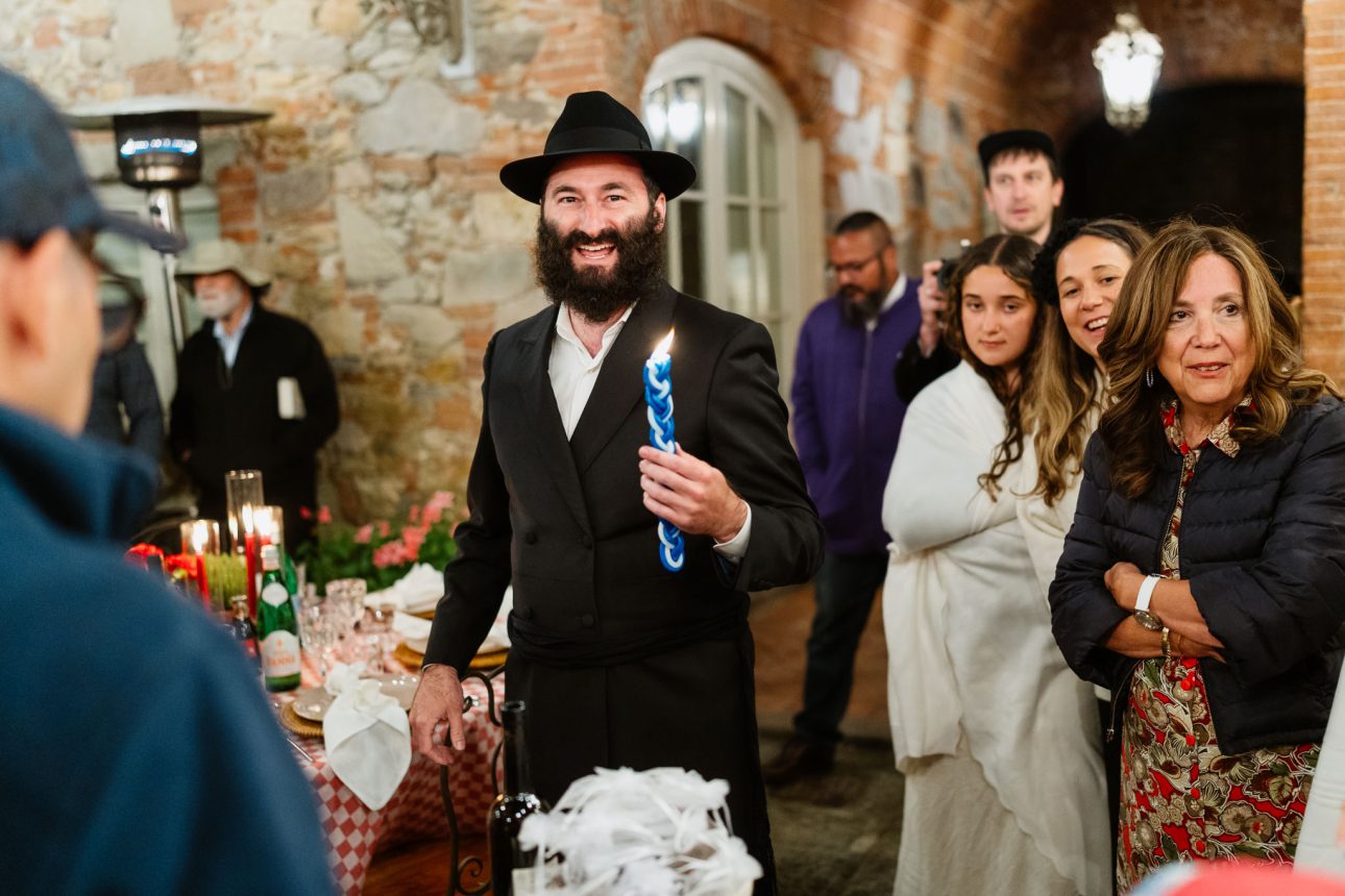 Rabbi lighting candle during Pizza Party luxury Jewish wedding Tuscany