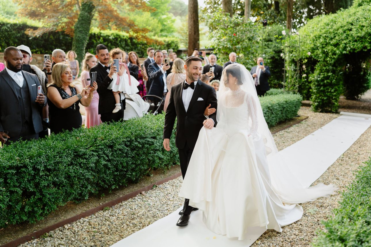 Emily and Refael walking down aisle Tuscany