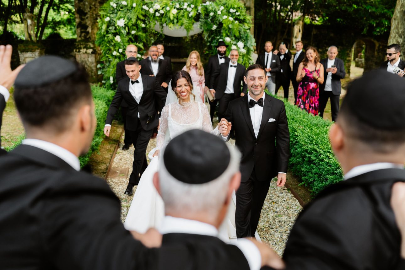 Just married couple walking out from under chuppah Tuscany